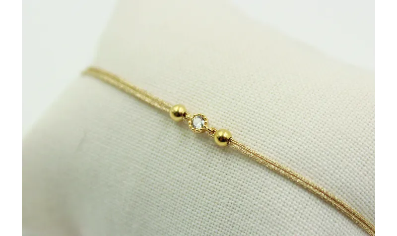 Pulsera de macrame en color oro palido y brillo de