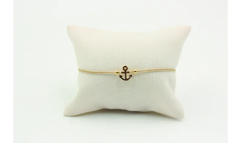 Pulsera de macrame en color oro palido y ancla dor