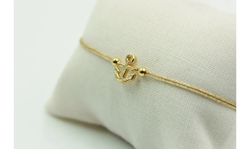 Pulsera de macrame en color oro palido y ancla dor