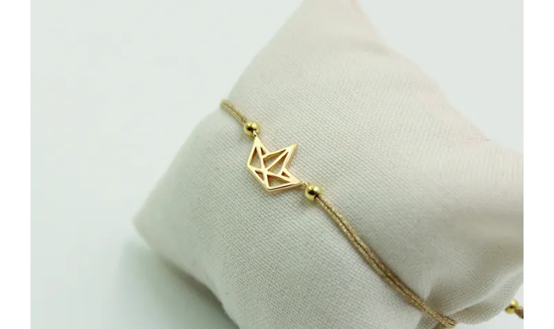 Pulsera de macrame en color oro palido y barco dor
