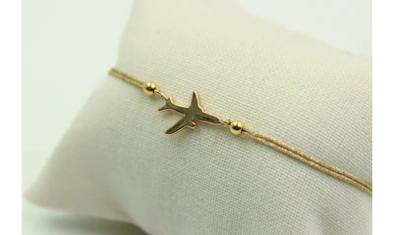 Pulsera de macrame en color oro palido y avión dor