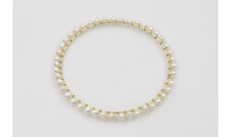 Pulsera rigida dorada con perlas naturles cosidas 