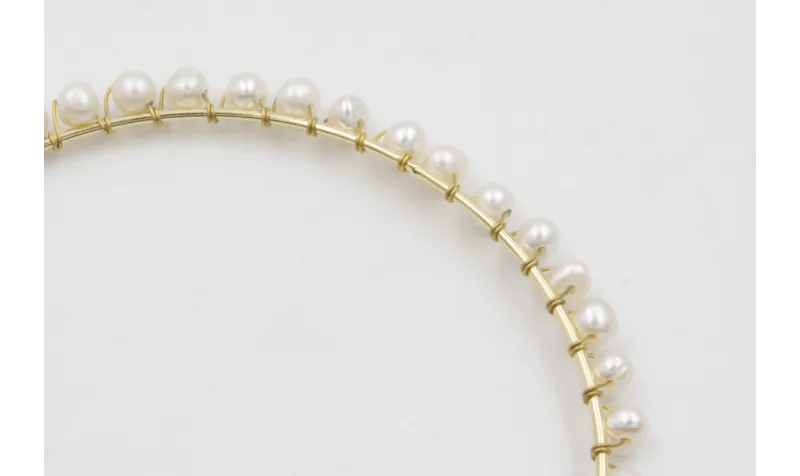 Pulsera rigida dorada con perlas naturles cosidas 