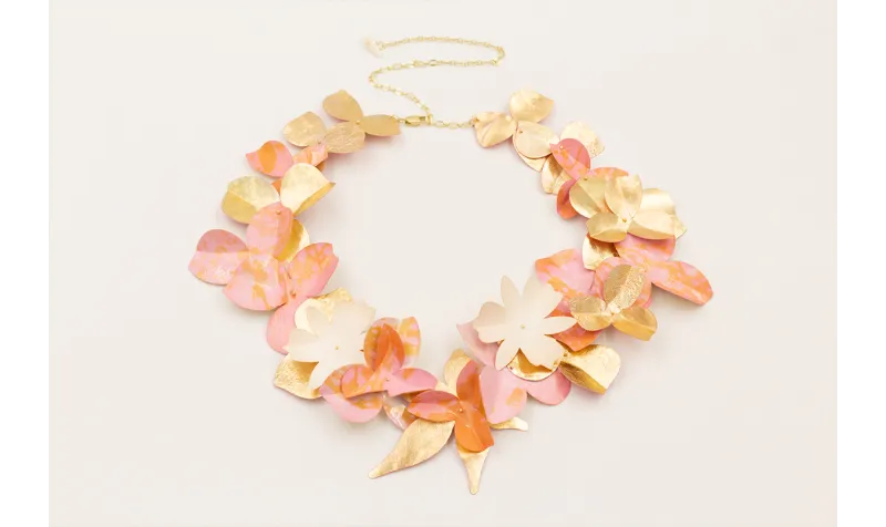 Collar de flores de lentejuelas rosas y doradas.