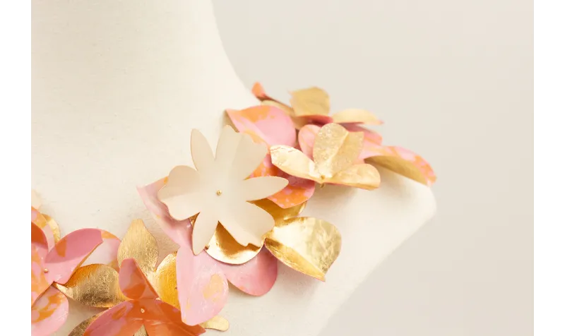 Collar de flores de lentejuelas rosas y doradas.