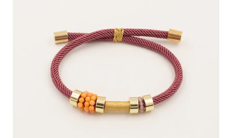 Pulsera cordón retorcido color coral,ruedas dorada