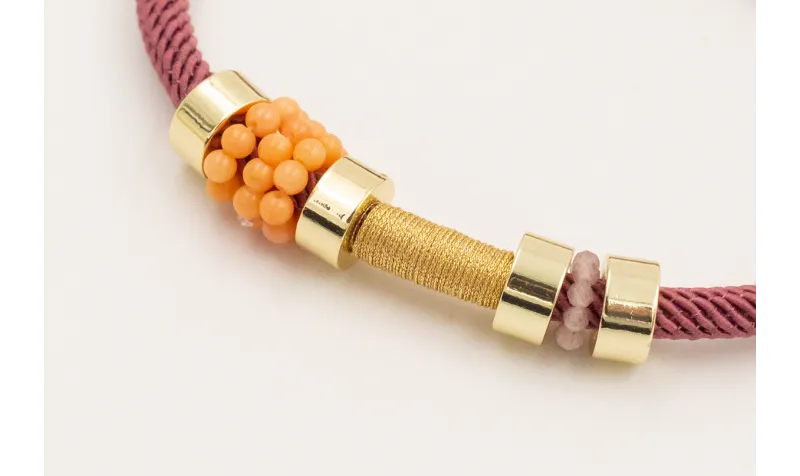 Pulsera cordón retorcido color coral,ruedas dorada