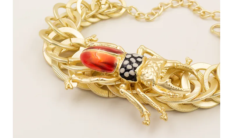 Pulsera aros entrelazados dorado mate con escaraba